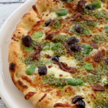 Pizza With Fava Bean Pesto, Fresh Fava Beans, Black Olives & Taleggio Cheese